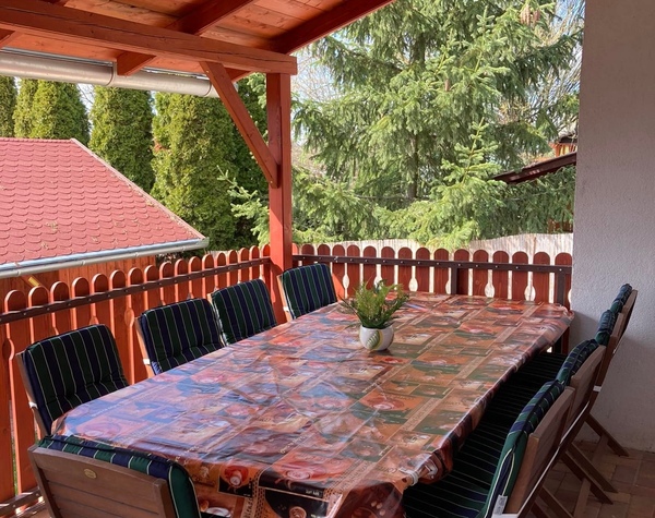 Fedett terasz nagy étkezőasztallal a vízparti nyaralóban